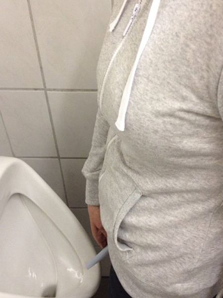 Frau-im-Pissoir-mit_PIBELLA-TRAVEL_female-urine-device-in-Mens-toilet